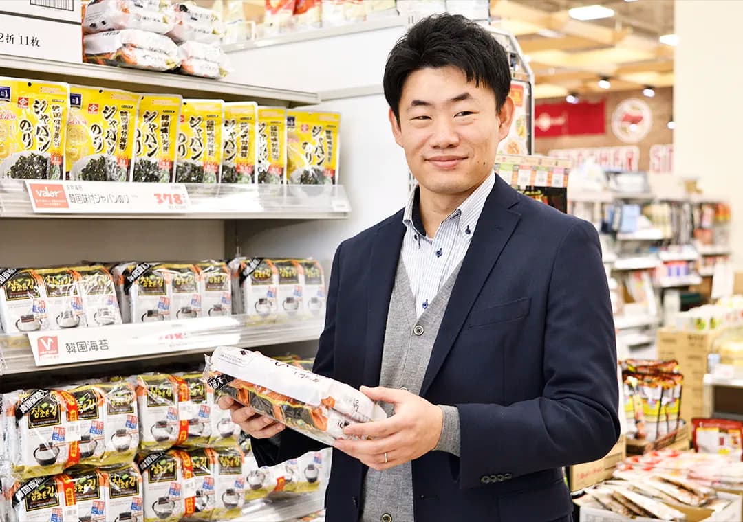 スーパーマーケットで商品を手に取る社員